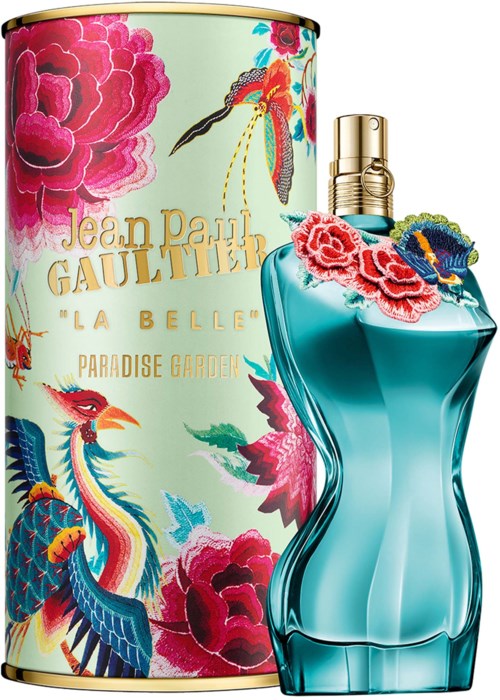 Ein Parfümflasche mit Blumendesign neben einem Behälter mit bunten Blumen und goldenen Akzenten.