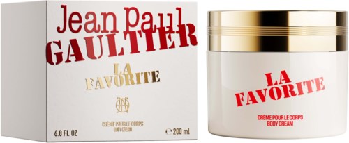 Een witte bodycrèmepot met een gouden deksel naast de verpakking, beide gemarkeerd La Favorite door Jean Paul Gaultier.