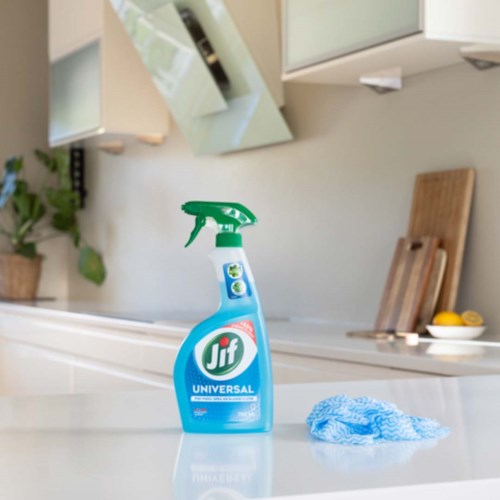 En Jif Universal rengjøringssprayflaske med en blå klut i et moderne kjøkken.