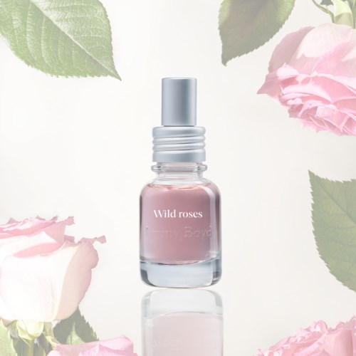 Hajuviljelaukku nimeltä Wild roses, ympärillä pinkkejä ruusuja ja vihreitä lehtiä.
