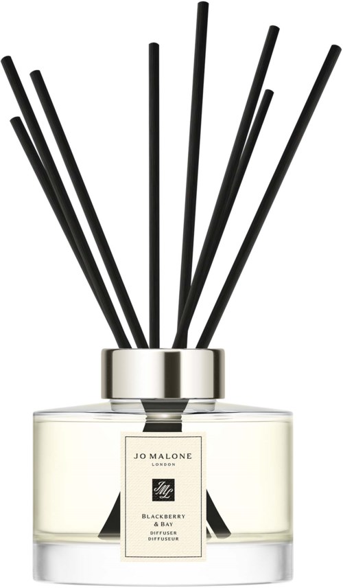 A jar of Jo Malone Blackberry & Bay diffuser with black sticks in a clear container.