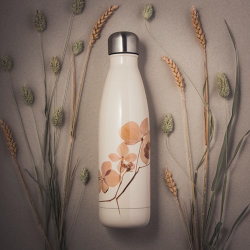 A white insulated bottle with floral design stands among dried plants on a neutral background.