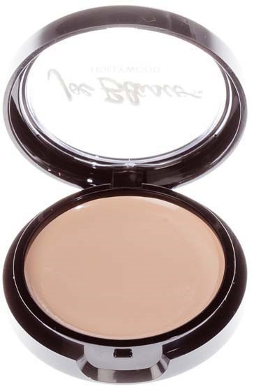 A compact with a mirror open, showing light beige powder inside.