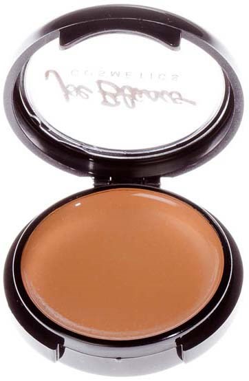 A compact with light brown makeup inside and a mirror on the lid reflecting some text.