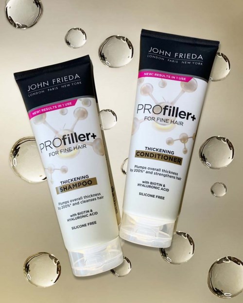 Two hair care tubes: shampoo and conditioner, on a light background with water droplets.