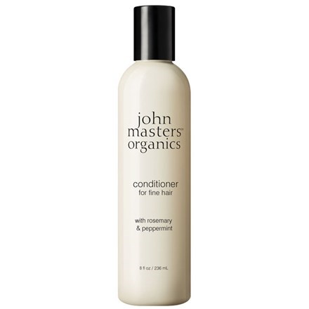 En flaska med John Masters Organics balsam med rosmarin och pepparmynta för fint hår.