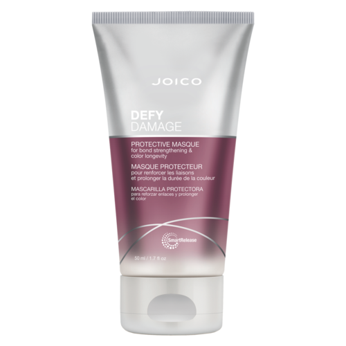 En tub med Joico Defy Damage skyddande hårmask, rosa och silverfärger, med text och branding.