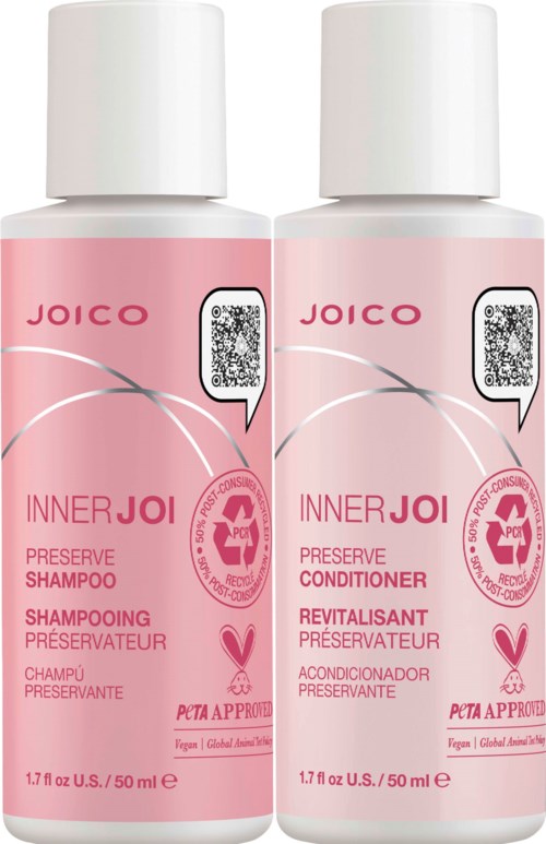 To rosa flasker med Joico hårpleieprodukter, en for sjampo og en for balsam, med hvite lokk og etiketter.