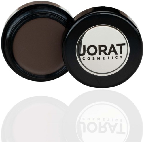 A round makeup container with dark brown product and a label that says 'Jorad Cosmetics.'