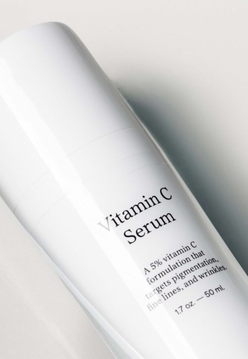En vit flaska märkt 'Vitamin C Serum' med information om dess C-vitaminformulering, 50 ml.