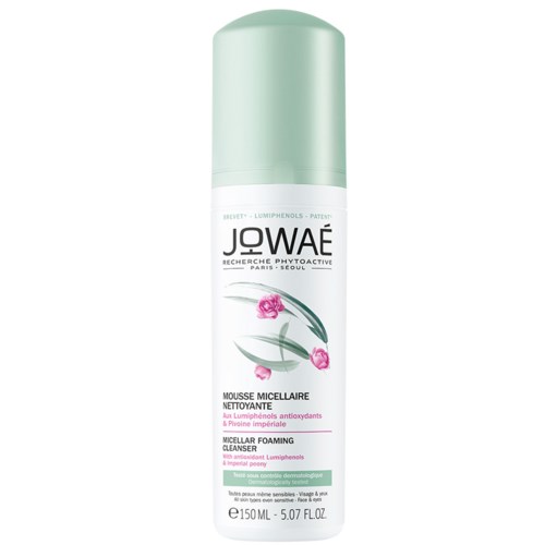 En lang hvid og grøn dåse med micellar skumrens med pink blomster og grønne blade på etiketten.