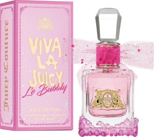 Rosa parfymflaska med stort kristalllock, rosa band och bubbeldekorationer; lådan är rosa med guld- och rosa text.
