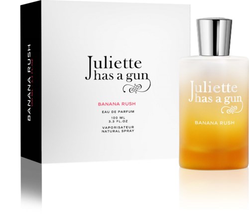 Een parfumfles met witte doos, beiden gelabeld Juliette Has a Gun Banana Rush, oranje en witte sprayfles.