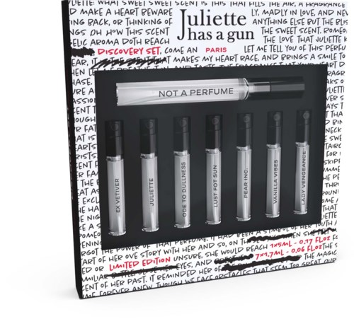 Et sæt med seks duftprøver med etiketter, i en æske mærket 'NOT A PERFUME', mod en håndskrevet baggrund.