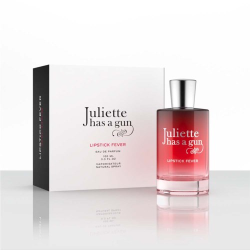 Hajuvesipullo ja laatikko, jossa lukee "Juliette Has a Gun Lipstick Fever." Pullo on pinkki ja hopea.