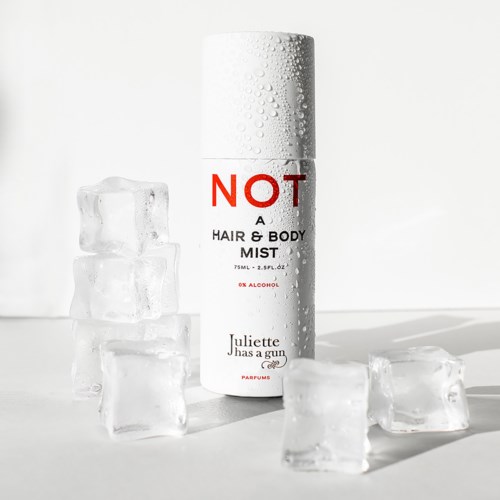 En vit sprayburk med texten "NOT A HAIR & BODY MIST" och isbitar runt den.