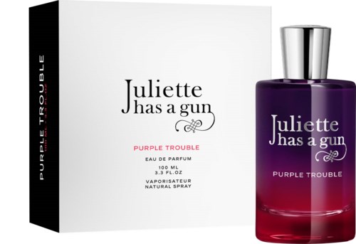Violetti ja musta laatikko vieressä violettia ja punaista hajuvesipulloa ja hopeista korkkia.