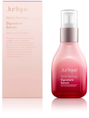 Eine rosa Flasche Jurlique Herbal Recovery Signature Serum neben Karton, beide mit weißen und roten Texten.