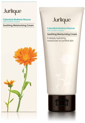 En hvid tube med Jurlique Calendula Redness Rescue-creme med sort låg, ved siden af en æske med en calendula-blomst.