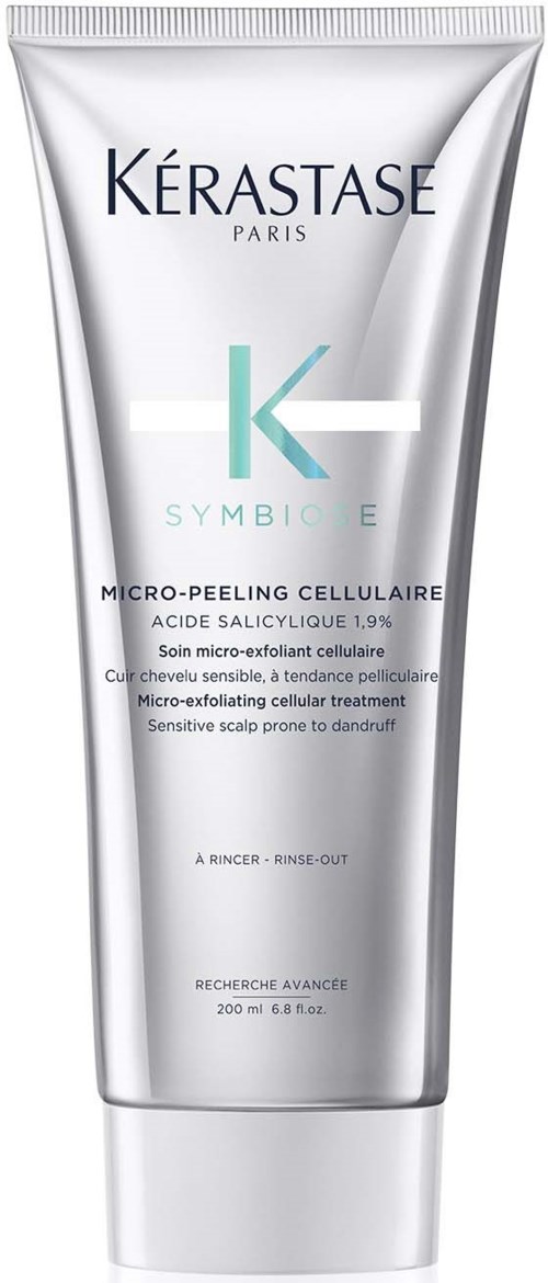 En silverfärgad tub med Kérastase Symbiose mikroexfolierande cellulära behandling. Tekster beskriver produkten.