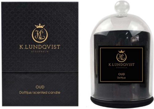 En svart förpackning och ett glasburk innehåller ett doftljus med svart vax, märkt K. Lundqvist, OUD, och inrymt i ett klart lock.