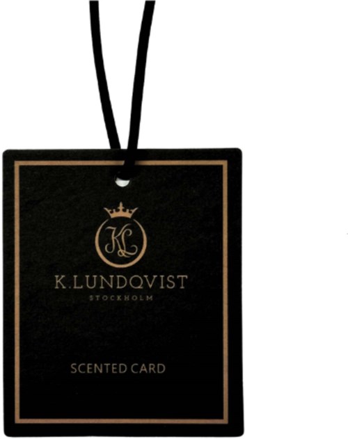 Et sort duftpaskelabel med gulddesign, logo og tekst, hængende med sort snor.