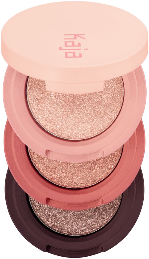 En stabel med fire runde, rosa og svarte øyeskyggepaletter med glitternyanser.