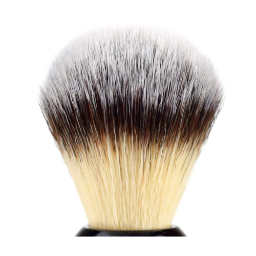 A close-up of a makeup brush with soft, dense bristles that are light at the tip and darker nearer to the base.