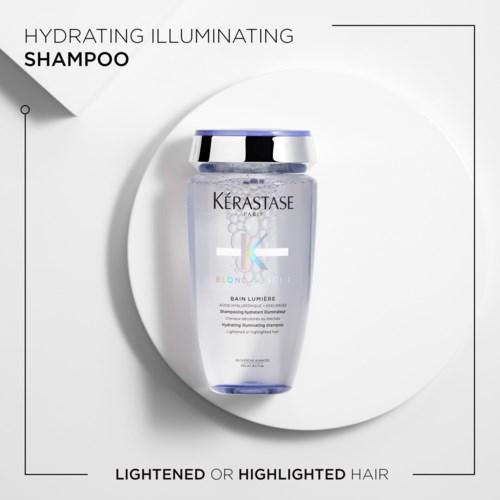 En tydlig flaska av Kérastase Hydrating Illuminating Shampoo på en vit bakgrund, som betonar hårets lystnad eller glans.
