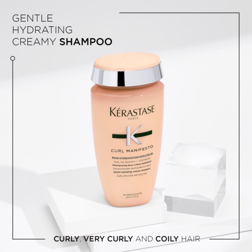 En flaske af Kérastase Curl Manifesto nærende shampoo til krøllet og krøllet hår, med tekst der beskriver dens milde, fugtgivende, cremet egenskaber.