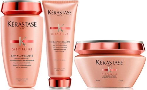 A hair care set with shampoo, conditioner, and mask in pink containers. Brand is Kerastase, called Discipline line.