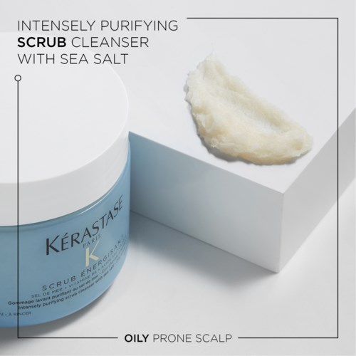 A blue jar labeled 'Kérastase' with a white lid, next to a cream-like substance on a white platform.
