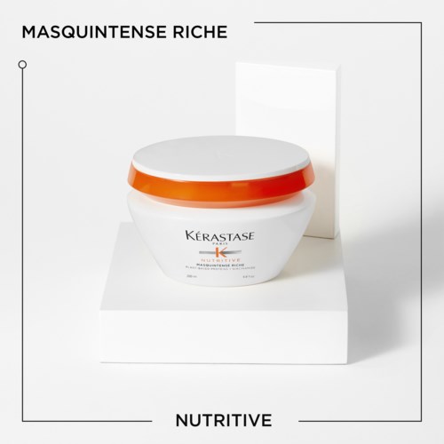 En burk med Kérastase hårinpackning med orange lock på en vit plattform, med texten: 'Masquintense Riche' och 'Nutritive.'