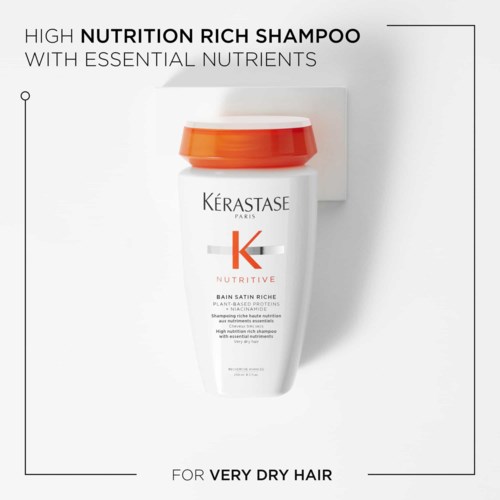 A white shampoo bottle with an orange cap featuring the Kerastase logo and product details for dry hair.
