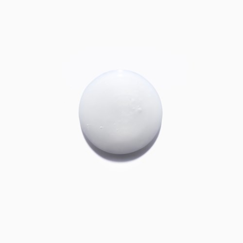 En enkel hvit rund pille eller tablet på en hvit bakgrunn.