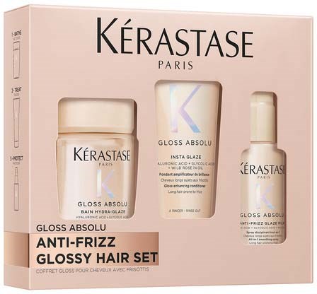 A pink box holds a skincare set with three products: a jar, a small box, and a bottle, all labeled Kérastase.