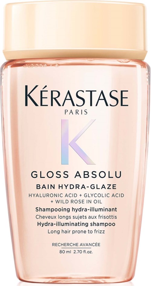 En rosa flaske Kérastase Gloss Absolu shampoo med beige låg, indeholder hårplejeingredienser.