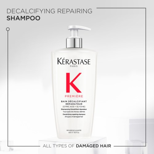 En vit schampoflaska med pump, märkta 'KERASTASE,' för skadat hår med aktiva ingredienser. Det är Premier Decalcifying Repairing Shampoo.