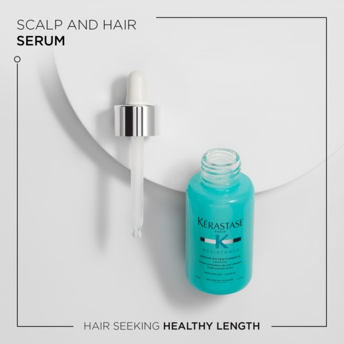 A blue hair serum bottle with a dropper cap on a white background, with text describing hair health benefits.