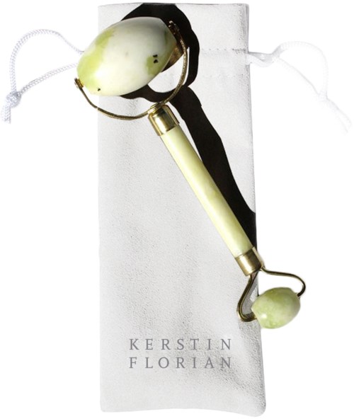 A facial roller with a white stone, placed on a white cloth with the name Kerstin Florian.