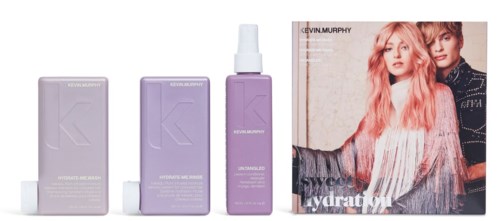 En uppsättning med lila hudvårdsprodukter med sprayflaska och ett magasin med två unga kvinnor.
