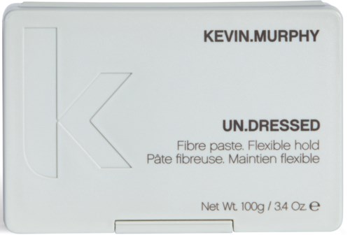 Ett vitt lock med text: Kevin.Murphy, UN.DRESSED, fiber paste, flexibel hållning och vikt. Boxen ser ut som förpackning för en hårprodukt.