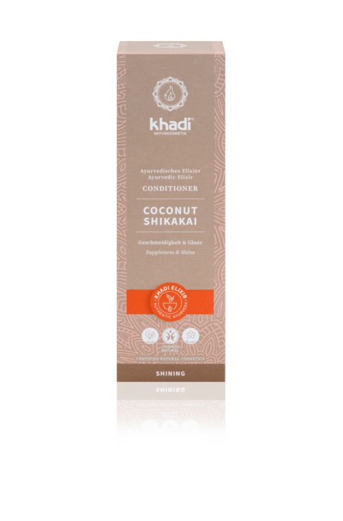 En lang, beige eske med Khadi kokosbalsam, med oransje og brune etiketter, og en hvit logo på toppen.