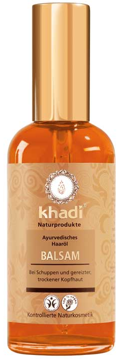 En flaska Khadi hårolja med guldkork, märkt som ayurvedisk och naturlig, avsedd för torr hårbotten.