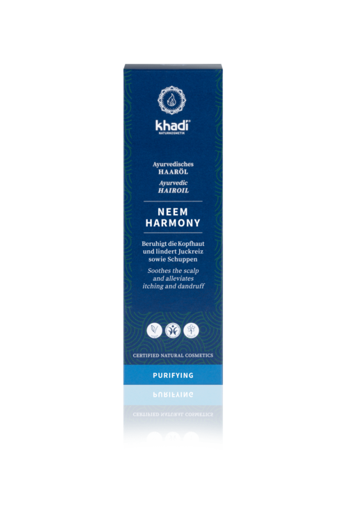 Eine blaue Schachtel mit Khadi Neem Harmony Haaröl, mit Produktdetails und Vorteilen für Kopfhaut und Haare.