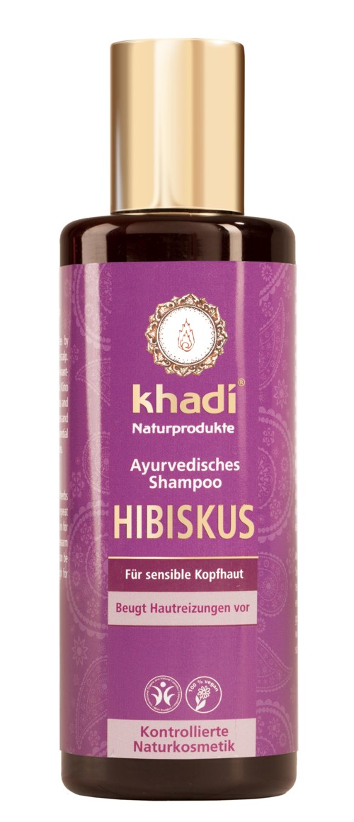 En flaska örtshampoo för känslig hårbotten, med lila etikett och guldlock. Den förhindrar hudirritation.