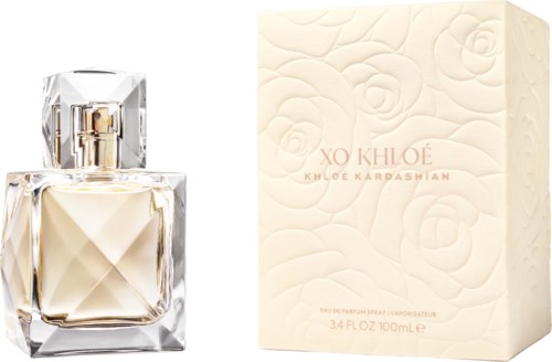 En parfymflaska med ett geometriskt glaskonstverk bredvid en blomsterpräglad box märkt XO KHLOE av Khloe Kardashian.