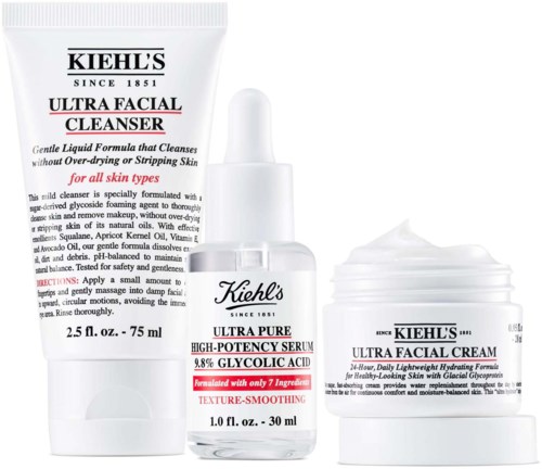 Three skincare products: a cleanser, a serum, and a facial cream, all from Kiehl's, in white packaging.