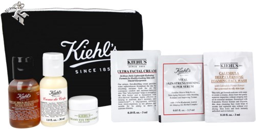En svart Kiehl's-påse med hudvårdsprodukter och informationspåsar utspridda framför.