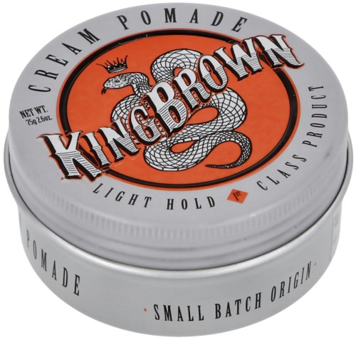 A metal tin of King Brown pomade with a snake logo, crown, and text about product qualities on the lid.